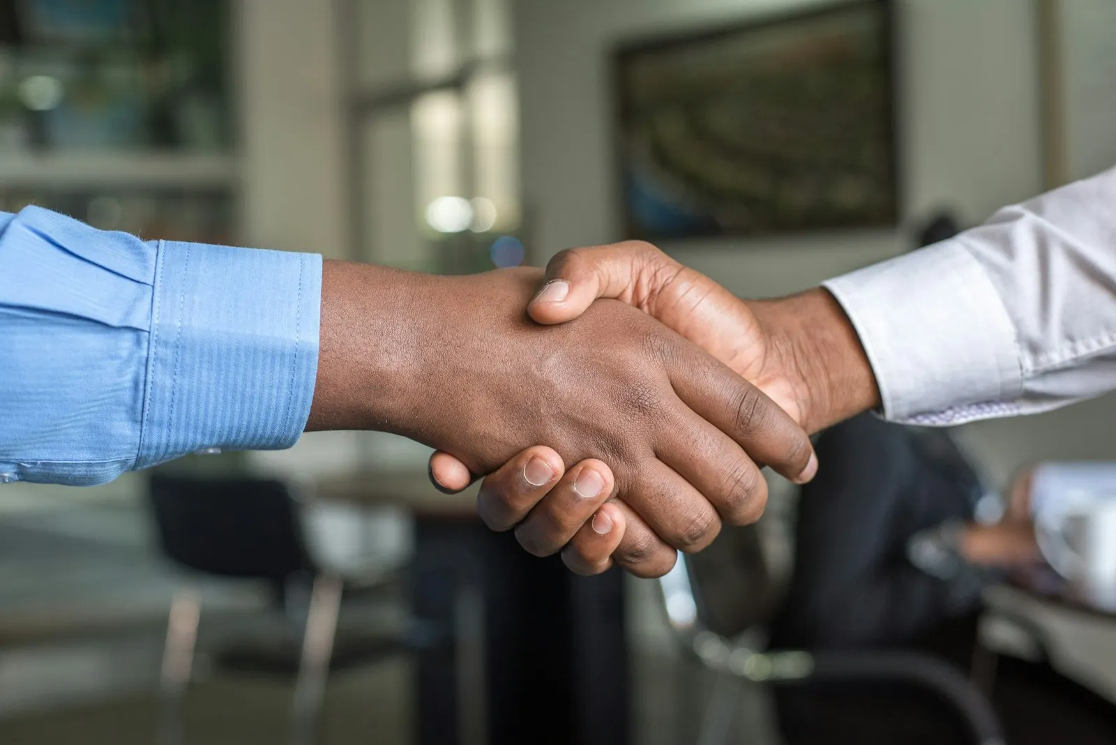 Geschäftlicher Handschlag im Büro als Zeichen für Partnerschaft